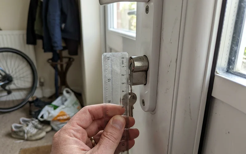Measuring how far a cylinder protrudes past the handle plate