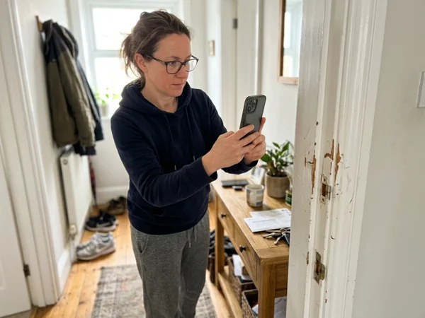 Homeowner photographing damage for an insurance claim
